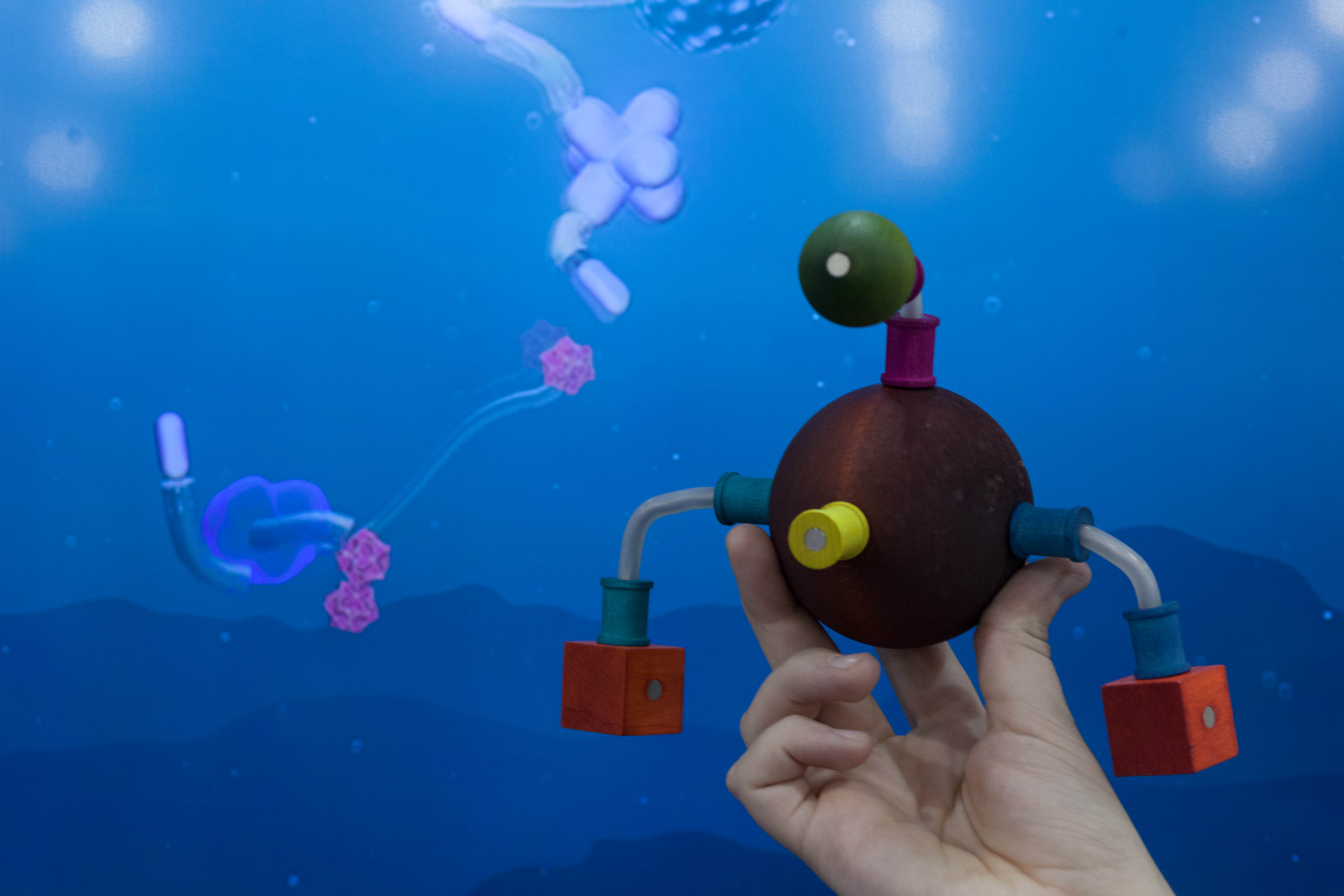 A participant holds a physical Curio in front of its virtual counterpart.