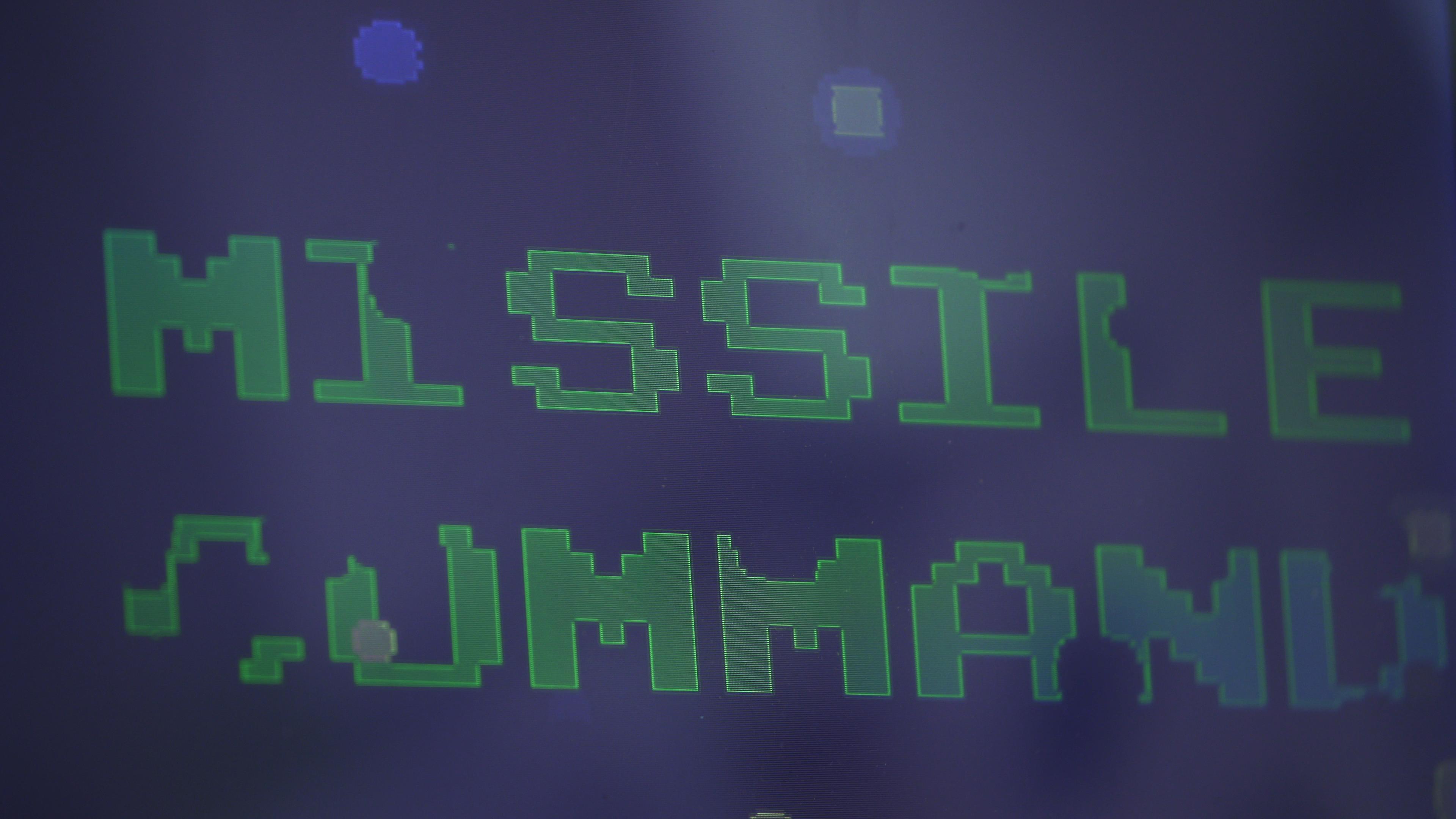 The green block-letter title MISSILE COMMAND appears on a dark blue Atari game screen.