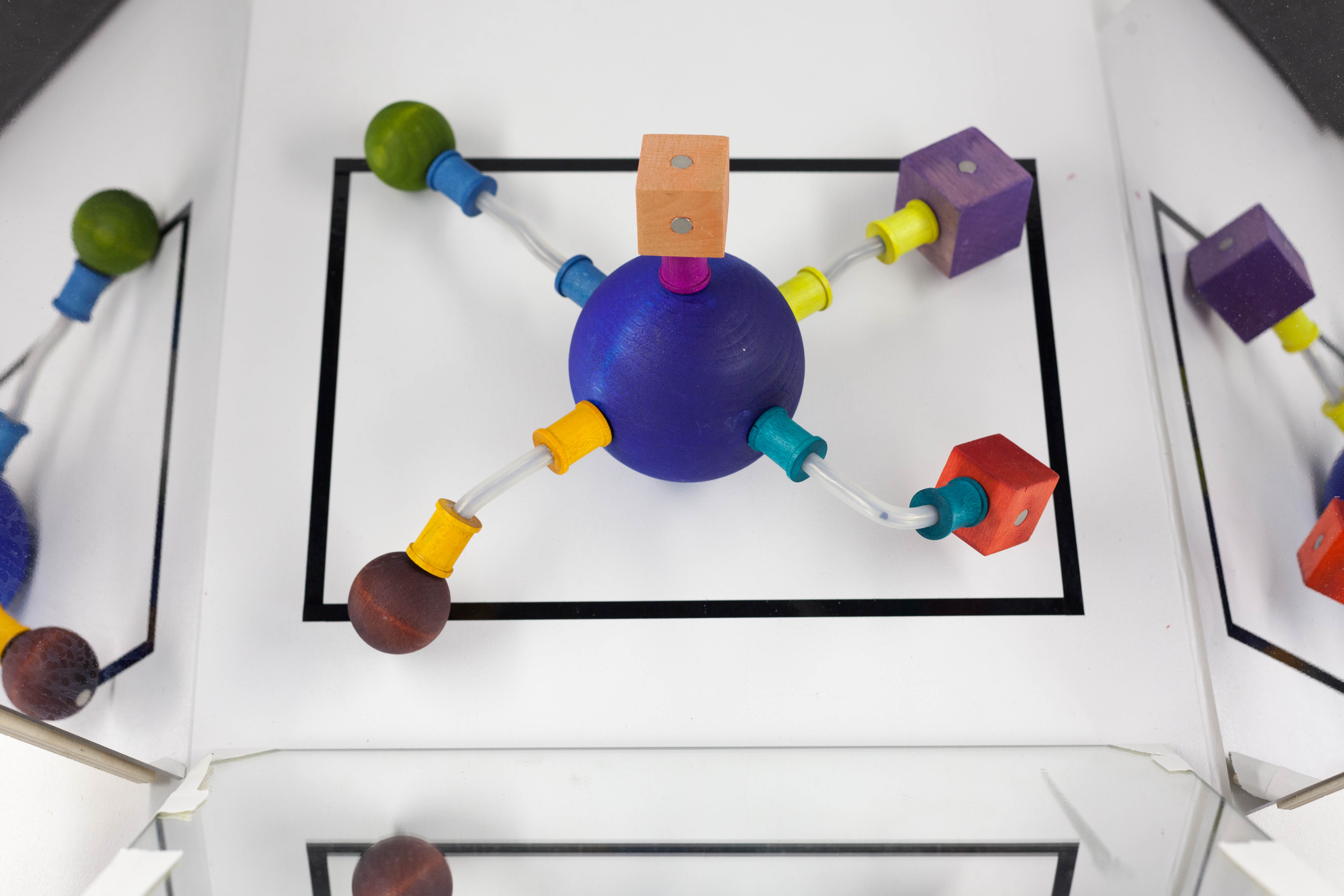 A 'curio' made of colored wood blocks sits inside a black rectangle.