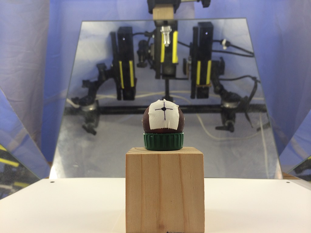 A studio test of a mirrored multi-Kinect calibration method, with a marked spherical target positioned before a mirror reflecting the camera array.