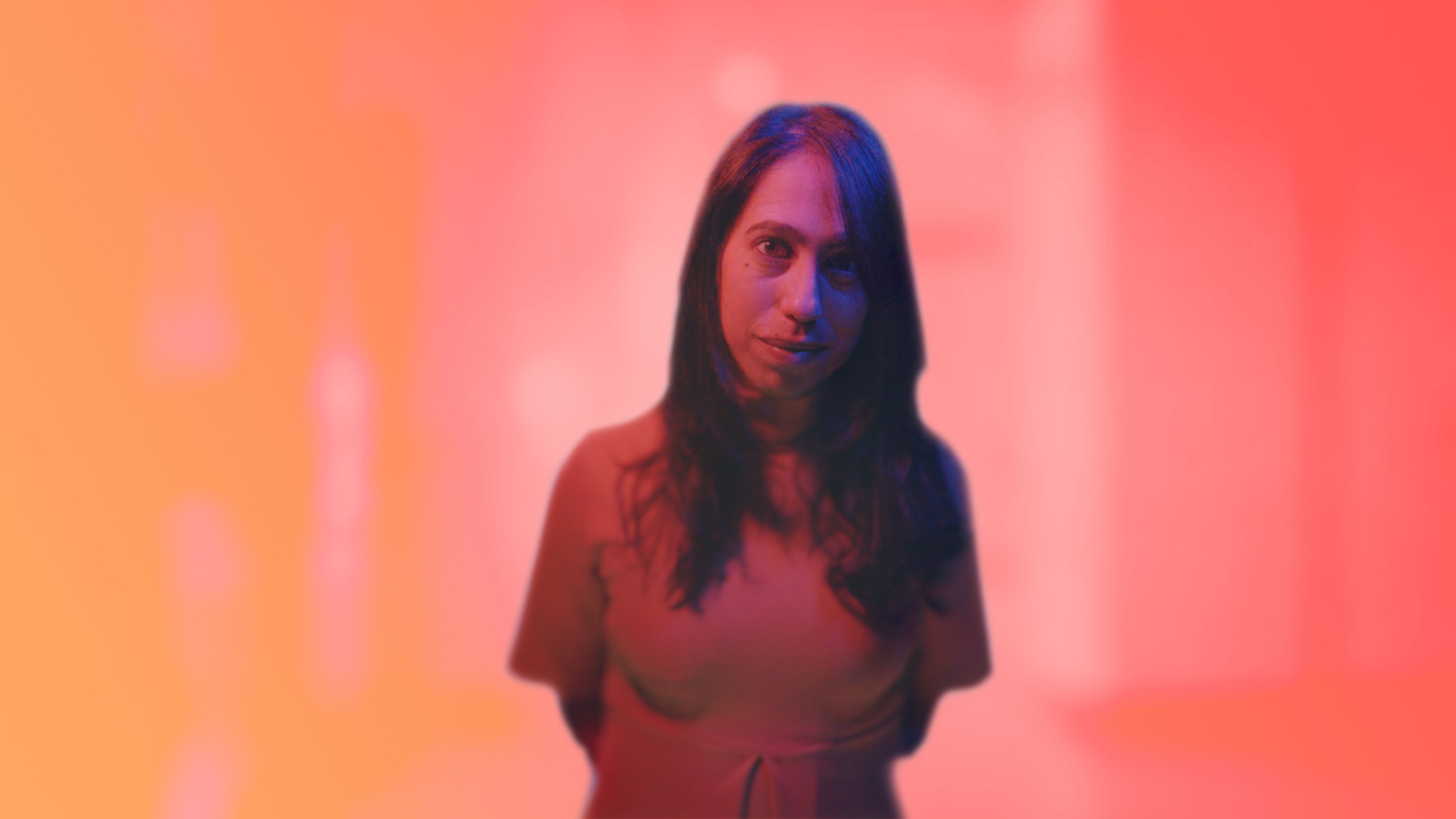 A performer appears as a warm orange volumetric portrait against a softly illuminated field.