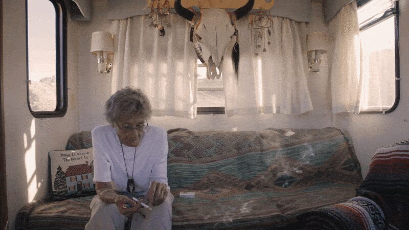Yvonne sits on a patterned couch inside her trailer.