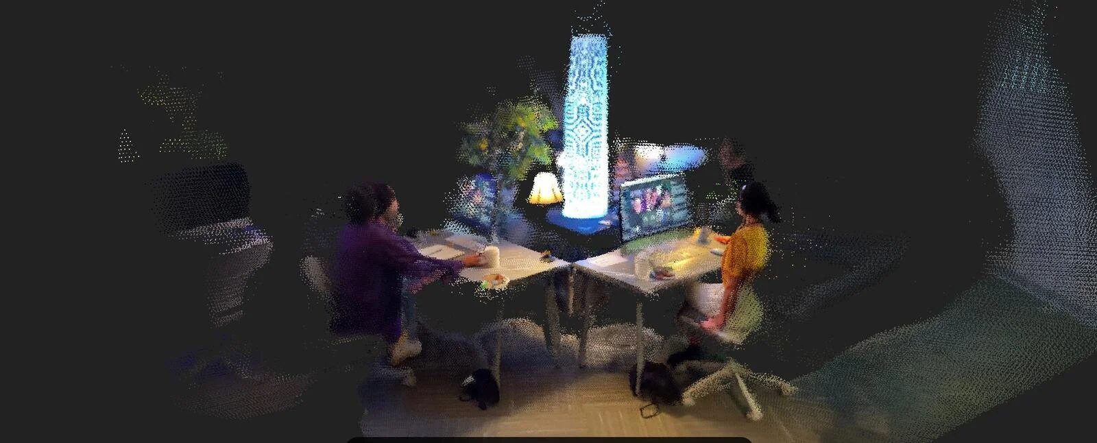Panoramic point-cloud image of two people seated at a table facing an online group, surrounded by tall patterned light columns.