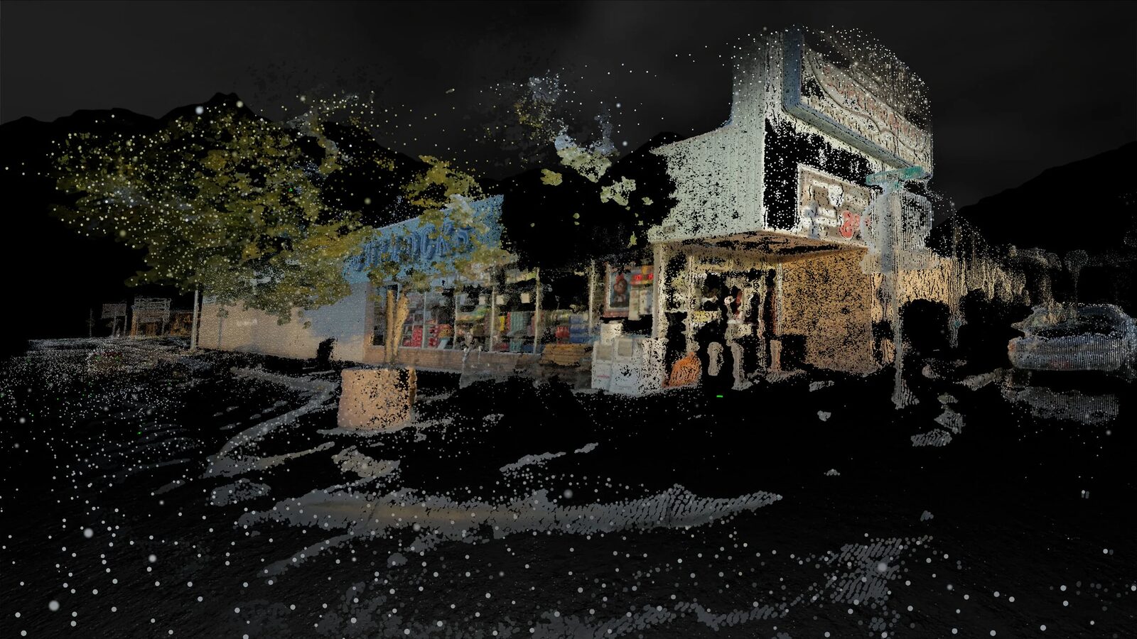 A wide point-cloud view of Bullocks grocery store and adjacent storefronts on the main street of Truth or Consequences, reconstructed against a black background.
